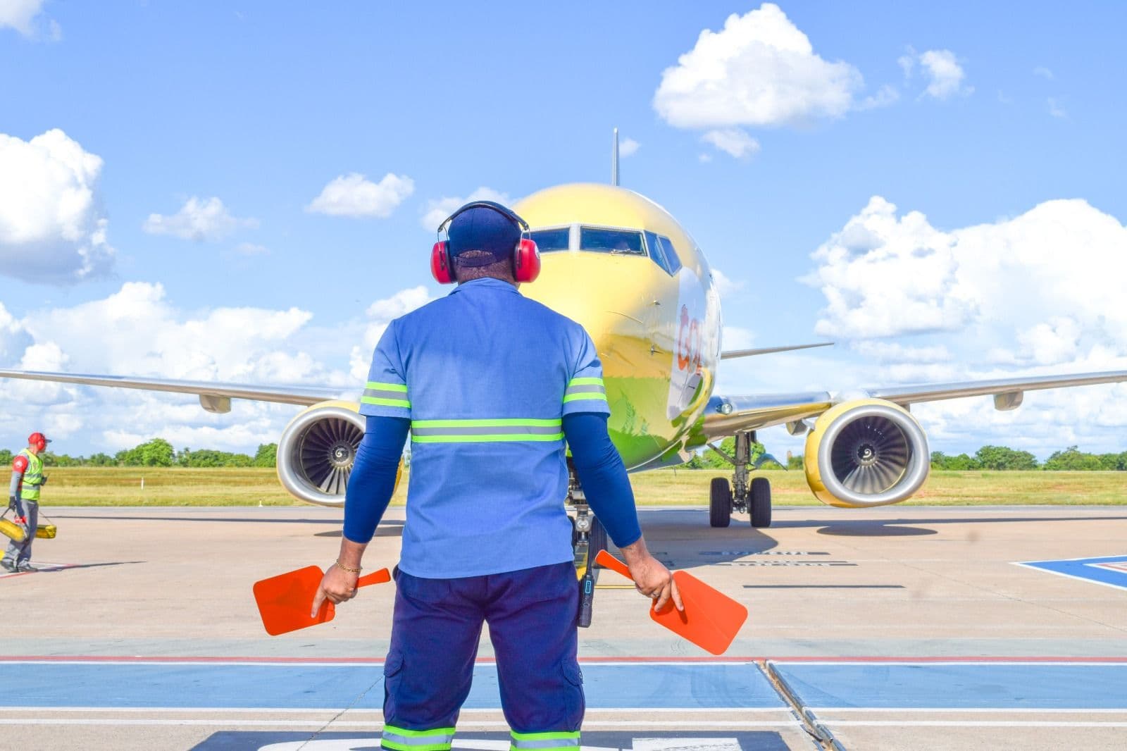 Funcionário sinaliza a aproximação de uma aeronave no pátio de um aeroporto do Bloco Centro-Oeste, em Mato Grosso